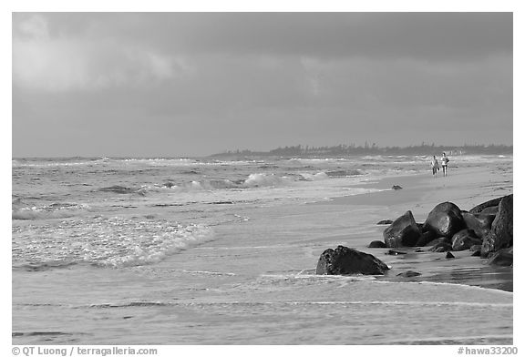 Couple strolling on the beach, Lydgate Park, early morning. Kauai island, Hawaii, USA (black and white)