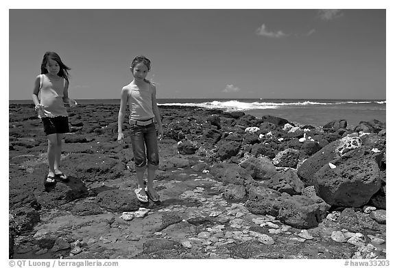 Girls playing in tidepool, Kukuila. Kauai island, Hawaii, USA