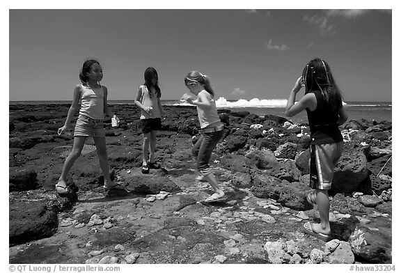 Girls playing in tidepool, Kukuila. Kauai island, Hawaii, USA