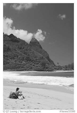 Woman sitting on a beach chair on Tunnels Beach. North shore, Kauai island, Hawaii, USA (black and white)