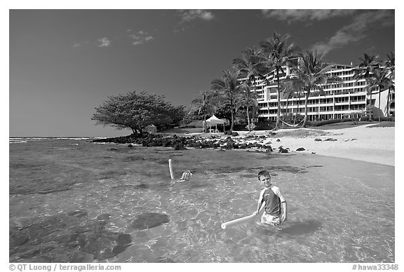 Children on Puu Poa Beach and Princeville Hotel. Kauai island, Hawaii, USA