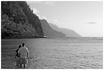 Couple standing in water, Kee Beach, late afternoon. Kauai island, Hawaii, USA (black and white)