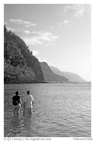 Couple looking at the Na Pali Coast, Kee Beach, late afternoon. Kauai island, Hawaii, USA (black and white)