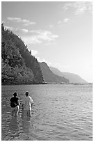 Couple looking at the Na Pali Coast, Kee Beach, late afternoon. Kauai island, Hawaii, USA (black and white)