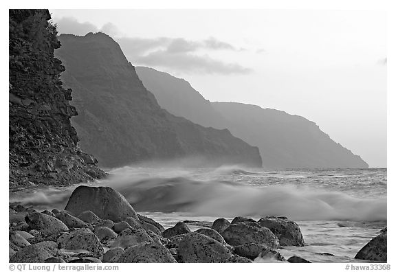Boulders, waves, and Na Pali Coast, sunset. North shore, Kauai island, Hawaii, USA (black and white)