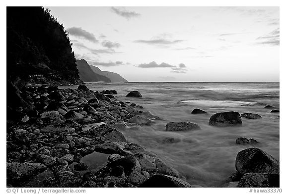 Boulders, waves, and Na Pali Coast, sunset. North shore, Kauai island, Hawaii, USA (black and white)