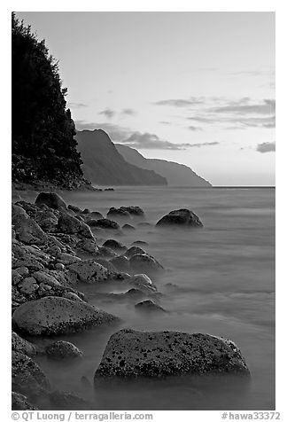 Boulders, surf, and Na Pali Coast, sunset. Kauai island, Hawaii, USA (black and white)