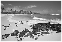 Dark rocks and Kiahuna Beach, mid-day. Kauai island, Hawaii, USA (black and white)