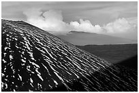 Cinder cone with snow stripes, distant clouds. Mauna Kea, Big Island, Hawaii, USA (black and white)