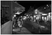 Tourists strolling store-lined street at night. Lahaina, Maui, Hawaii, USA ( black and white)