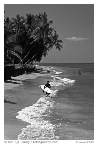 Surfer walking on beach. Lahaina, Maui, Hawaii, USA (black and white)