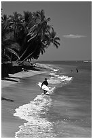 Surfer walking on beach. Lahaina, Maui, Hawaii, USA ( black and white)