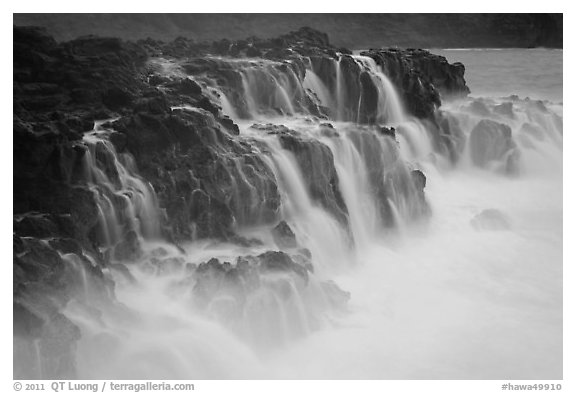 Surf cascading from volcanic shelf. Kauai island, Hawaii, USA (black and white)