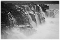 Surf cascading from volcanic shelf. Kauai island, Hawaii, USA (black and white)