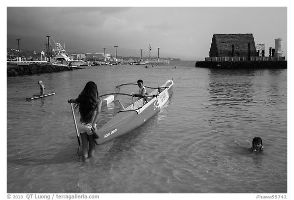 Girls, outrigger canoe, and Kamakahonu heiau, Kailua-Kona. Hawaii, USA (black and white)