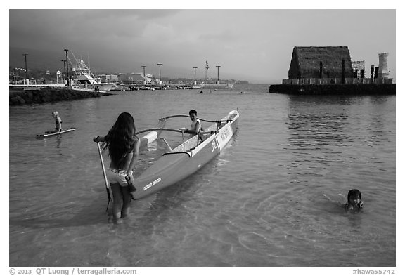 Girls, outrigger canoe, and Kamakahonu heiau, Kailua-Kona. Hawaii, USA