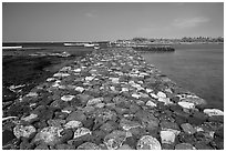 Rock wall separating Kaloko fishpond from the ocean, Kaloko-Honokohau National Historical Park. Hawaii, USA ( black and white)