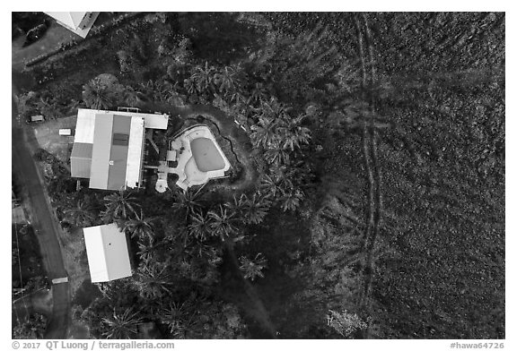 Aerial view of house and pool on edge of lava field. Big Island, Hawaii, USA (black and white)
