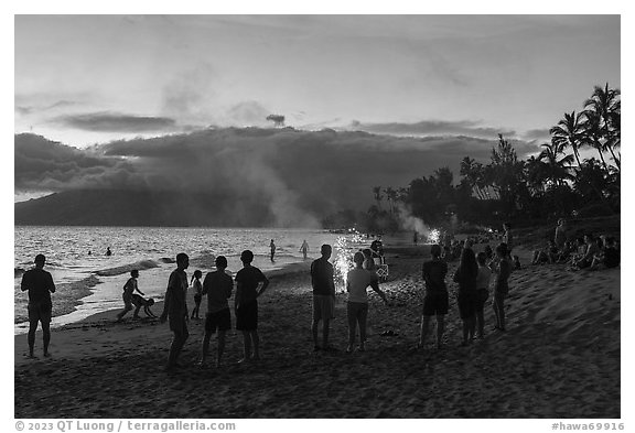 Revelers on Kamahole Beach with fireworks, Kihei. Maui, Hawaii, USA