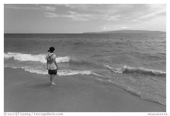 Girl stepping into water, Big Beach. Maui, Hawaii, USA (black and white)