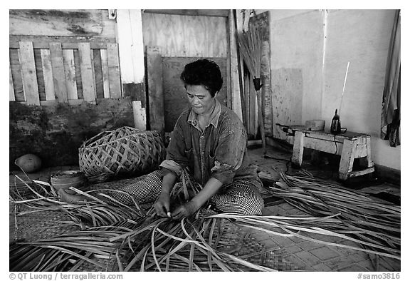 Woman weaving toga out of pandamus leaves, Tau Island. American Samoa (black and white)