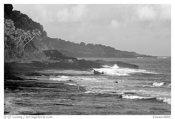 Fisherman on rocky coast near Vailoa. Tutuila, American Samoa (black and white)