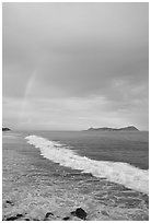 Rainbow at sunset, wave, and Aunuu island. Aunuu Island, American Samoa ( black and white)