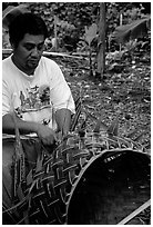 Villager weaving a basket out of a single palm leaf. Tutuila, American Samoa (black and white)