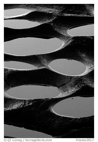 Water-filled  grinding stones holes (foaga) near Leone at sunset. Tutuila, American Samoa (black and white)