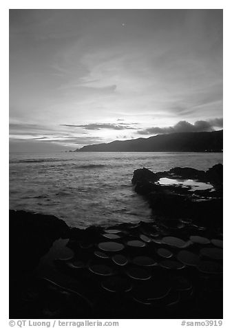 Water-filled  grinding stones holes (foaga) and Leone Bay at sunset. Tutuila, American Samoa