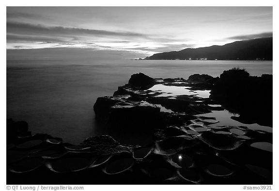 Grinding stones holes (foaga) filled with water at dusk, Leone Bay. Tutuila, American Samoa (black and white)