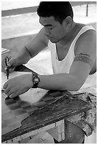 Young man drawing an artwork based on traditional siapo designs. Pago Pago, Tutuila, American Samoa (black and white)