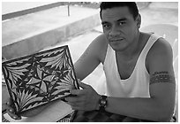 Young man showing an artwork based on traditional siapo designs. Pago Pago, Tutuila, American Samoa (black and white)