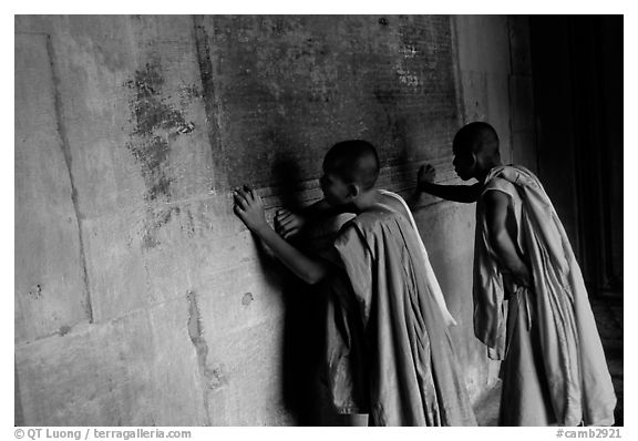 Two buddhist monks examine  bas-reliefs in Angkor Wat. Angkor, Cambodia (black and white)