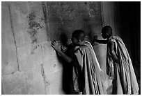 Two buddhist monks examine  bas-reliefs in Angkor Wat. Angkor, Cambodia (black and white)