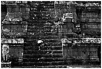 Boy climbs near-vertical staircase, Angkor Thom complex. Angkor, Cambodia (black and white)