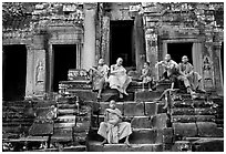 Buddhist monks sitting on steps, Angkor Wat. Angkor, Cambodia (black and white)