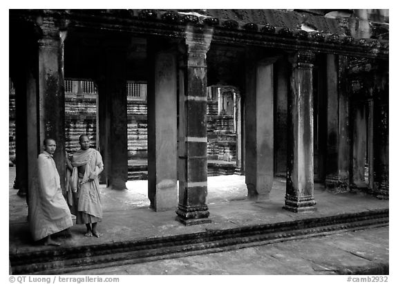 Two Buddhist monks in dark temple, Angkor Wat. Angkor, Cambodia