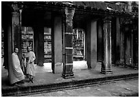 Two Buddhist monks in dark temple, Angkor Wat. Angkor, Cambodia (black and white)