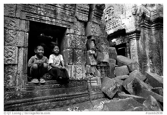 Boy and girl sit at window in Ta Prom. Angkor, Cambodia