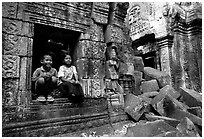 Boy and girl sit at window in Ta Prom. Angkor, Cambodia ( black and white)