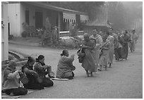 Women line up to offer alm to buddhist monks. Luang Prabang, Laos (black and white)