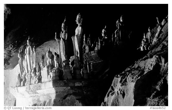 Hundreds of wooden Buddhist figures on wall shelves, Pak Ou caves. Laos (black and white)