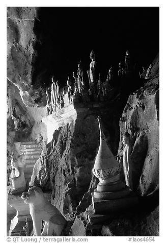 Buddhist statues left by pilgrims, lower Pak Ou cave. Laos (black and white)