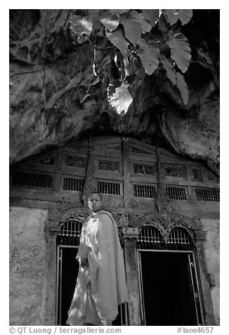 Novice Buddhist monk at entrance of lower Pak Ou cave. Laos (black and white)