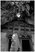 Novice Buddhist monk at entrance of lower Pak Ou cave. Laos (black and white)