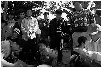 Coaches take care of wounded roosters after fighting. Luang Prabang, Laos (black and white)