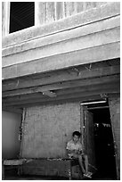 Boy at the entrance of traditional hut, Ban Xang Hai. Laos (black and white)