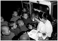 Novice during alm round at Mahamuni Paya. Mandalay, Myanmar (black and white)