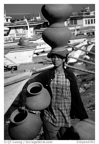 Carrying many jars. Mandalay, Myanmar (black and white)